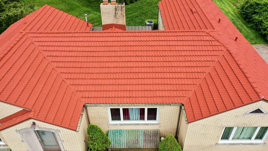 Brick ranch home after new stone-coated metal barrel tile roof installation